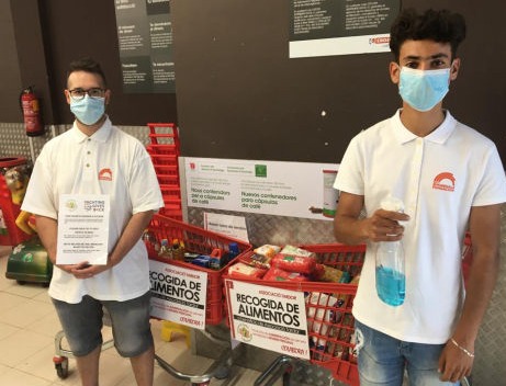 Two young boys man the collection trolleys at a supermarket
