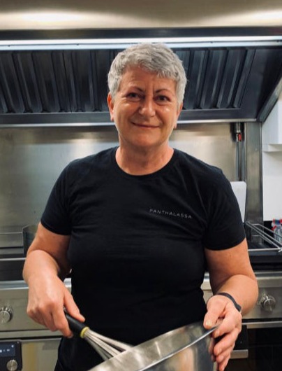 A woman with a bowl and a whip in a galley