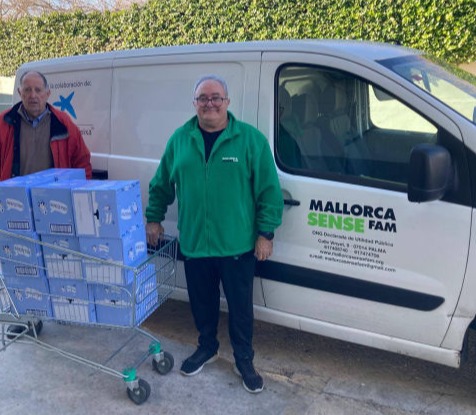 A group of people in front of a car, bringing a donation