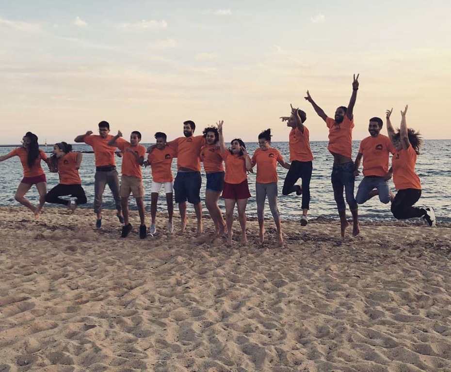 A group of youngsters doing a simultaneous jump on the beach