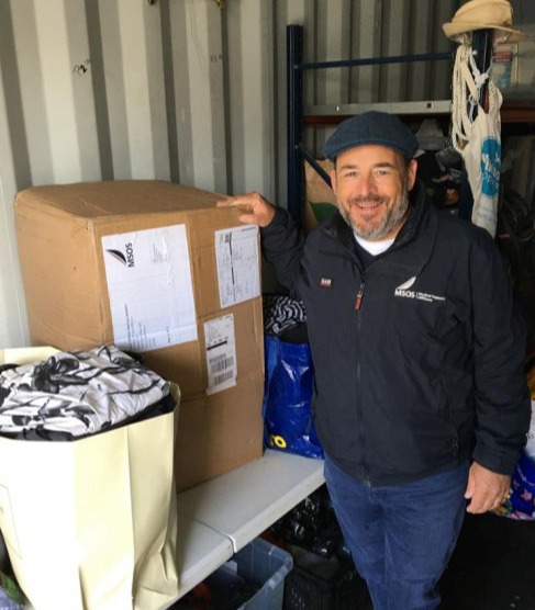 A man standing next to donated supplies in the container