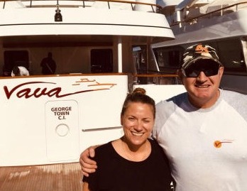 A woman and a man standing side by side behind a yacht