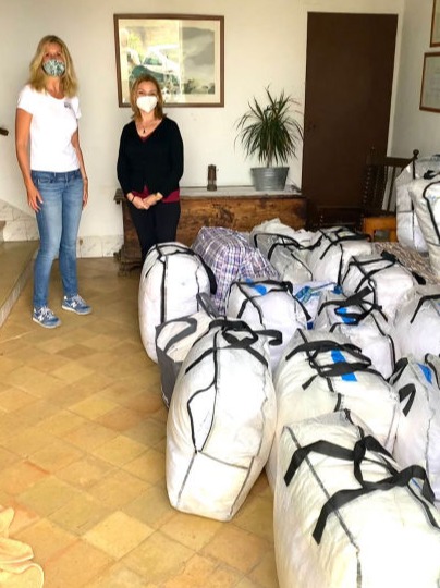 Two ladies next to bags of bedding