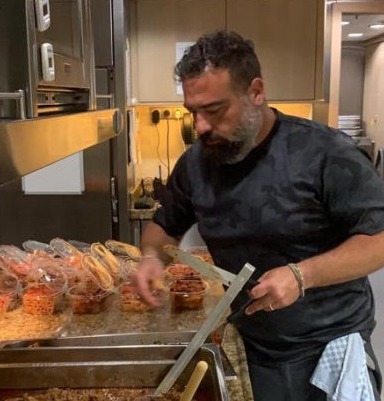 A male chef preparing food in the galley