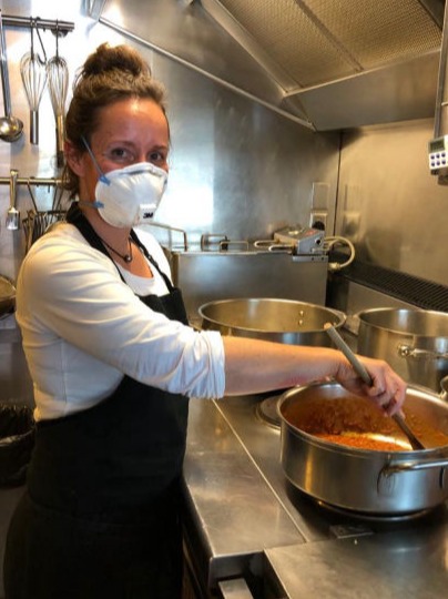 A woman stirring a pot in a galley