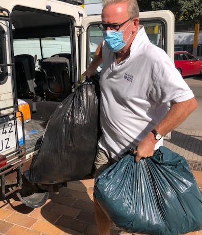 A man carrying plastic bags full of clothing