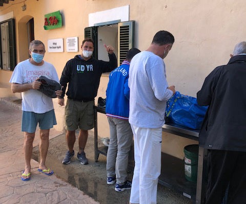 Various residents of Es Refugi selecting donated clothing