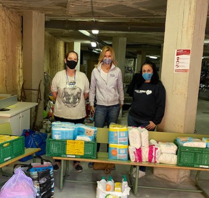 Volunteers next to donated baby equipment