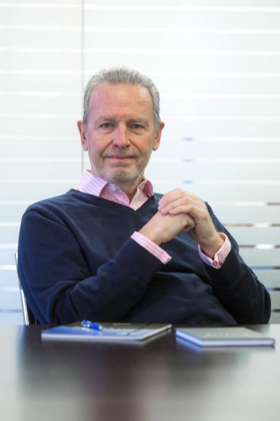 A man sitting behind a desk looking at the camera