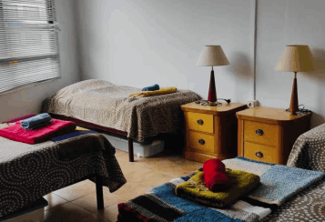 Four neatly made beds in a dormitory