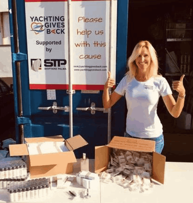 A woman showing thumbs up in front of a container