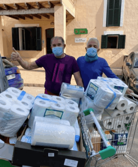 Two men behind a trolley full of toiletries at the shelter Es Refugi