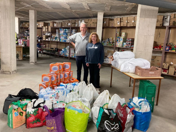 Volunteers next to donated baby equipment